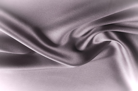 Texture fabric background. Black white silk fabric. Fragment of an abstract background of luxurious fabrics or liquid waves or wavy folds of a grunge silk texture of a satin velvet materialの写真素材