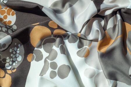 Texture, background, pattern. Abstract pattern on a silk fabric, white yellow brown circles