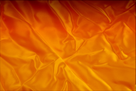 Texture, background, pattern. Red, yellow gold shades of silk fabric, text space. Gold satin texture, red silk background based on natural textureの写真素材