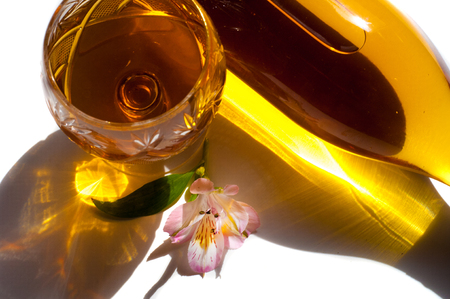 A bottle of white wine, Crystal Fougeres with white wine, a flower as a decoration. Isolated on white backgroundの写真素材