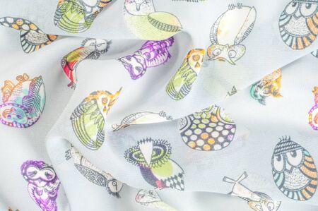 Texture, background, pattern. Silk fabric with a picture of birds, an owl, an owl.の写真素材