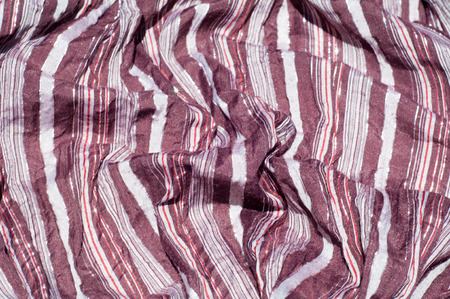 Texture, background, pattern. Female striped scarf, cloth striped brown, white, red with glitter