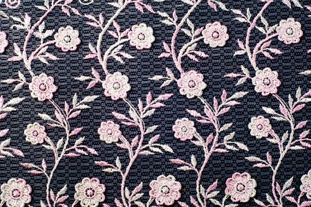Texture, background, pattern. Pink lace decorated with flowers on a black background. Lace decorated...
