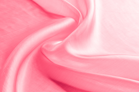 Background texture, pattern. Cloth pink silk. Smooth elegant pink silk or satin can use as wedding background. Luxurious valentine day background design.の写真素材
