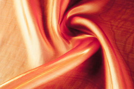 Background texture, pattern. Cloth is orange. Yellow silk fabric background is elegant and gentle. Bright satin fabric folded for use as a background. Upper type of fabric Textile surface. Text spaceの写真素材