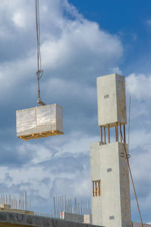Photo of a house under construction. Building under construction. Lifting cranes and building under...