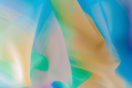 Blurry, not sharp sharpness Texture, background, pattern. Silk fabric is transparent, yellow-pink green in blue. Abstract soft chiffon texture background.の写真素材