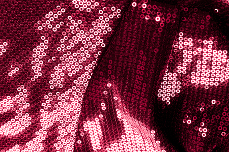 Background texture, pattern. Cloth red maroon with paillettes. Look at these Neon Pink Paillette Sequins. Round neon pink paillette sequins overlap with an iridescent sheen across a sheer purple meshの写真素材