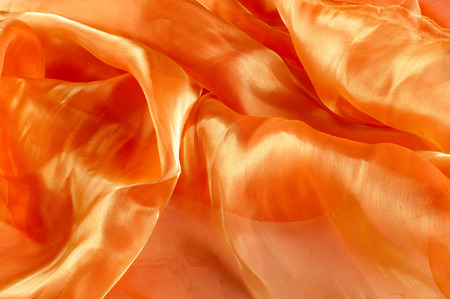 Background texture, pattern. Cloth is orange. Yellow silk fabric background is elegant and gentle. Bright satin fabric folded for use as a background. Upper type of fabric Textile surface. Text spaceの写真素材