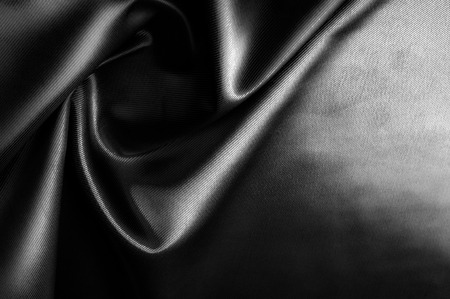 Texture, background, pattern. Black silk fabric.Pure Silk Charmeuse Crepe Backed Satin in BLACK fabric. Wide Stretch Silk Charmeuse Black By the Yardの写真素材