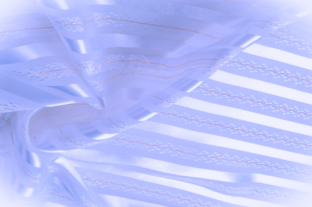 Background texture, pattern. Pastel. Blue silk fabric with a light strip. Smooth elegant blue silk or satin luxurious fabric texture can be used as an abstract background. Luxurious background designの写真素材