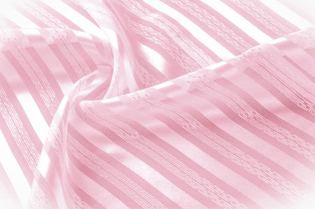 Background texture, pattern. Pink silk fabric with a light stripe. A smooth elegant pink silk or satin texture can be used as a background. Trend of color rose quartz pink pastel toneの写真素材