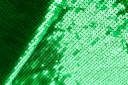 Background texture, pattern. The fabric is dark green with sequins. Make a statement with sequins ! Presenting the stylish Two-toned Paillette Sequins on the nylon spandex stretch backing.の写真素材
