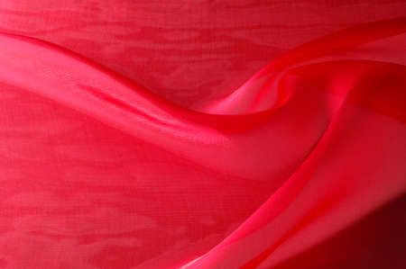 Texture, background, pattern. Red silk transparent fabric cloth texture. This is a stretch tulle, great for dresses or costumes where transparency and give is needed.の写真素材