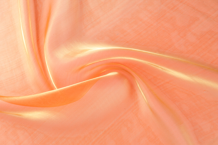 Background texture, pattern. Cloth is orange. Yellow silk fabric background is elegant and gentle. Bright satin fabric folded for use as a background. Upper type of fabric Textile surface. Text spaceの写真素材