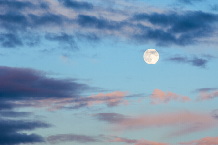 Evening landscape at sunset. The sky with the full moon. Severe storm clouds with pastel tones.の写真素材