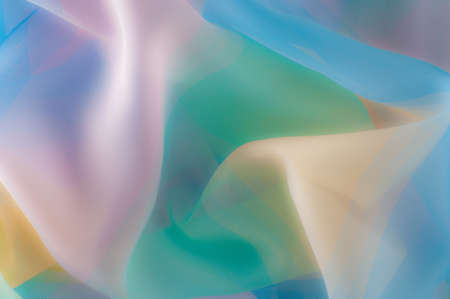 Blurry, not sharp sharpness Texture, background, pattern. Silk fabric is transparent, yellow-pink green in blue. Abstract soft chiffon texture background. の写真素材