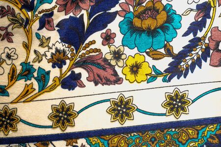 Texture, pattern, background. Silk fabric - multi colored flowers on a beige background.  Colourful...