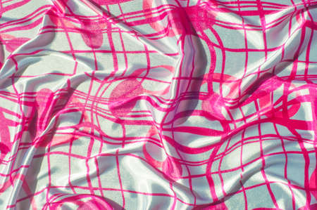 Background texture Silk. The fabric is white in steel color, the fabric is painted with red lines. Mixing elegance and edges, a solid oily red frame falls into a slim design on a white background.の写真素材