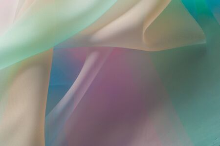 Texture, background, pattern. Silk fabric is transparent, yellow-pink green in blue. Abstract soft chiffon texture background. の写真素材