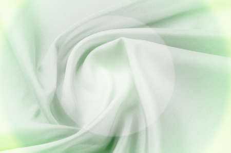 Texture background of fabric. As a background, you can use silk green fabric, smooth elegant green silk or satin. Green abstract fabric background or liquid wavesの写真素材