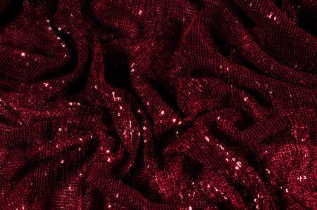 Texture, background, pattern, red fabric with paillettes. Look at these neon red sequins. Round neon pink sparkles glitter overlapping iridescent glitter on a clean purple grid.の写真素材