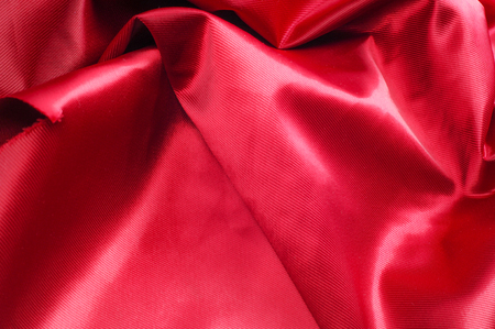 Texture, background, pattern. Red silk fabric.This satin fabric is perfect for making fabric flowers for use in hair accessories, jewery making, and fabric bouquets. の写真素材