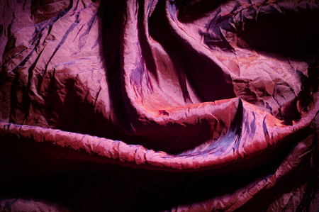 Texture, background, pattern. fabric silk dark maroon. Silk organza mood, but with a beautiful satin face. This fabric has a crunchy drape of organza, but one face is a brilliant satin.の写真素材