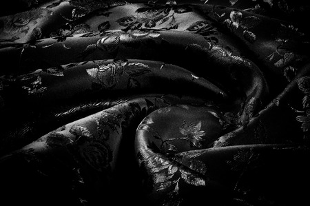 fabric, background texture. silk black fabric with a pattern of flowers. Get lost in the beautiful illustrated floral print in this black and white silk frame.の写真素材