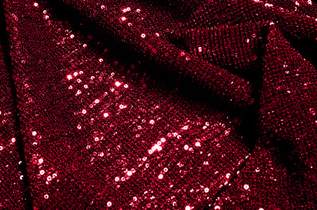 Texture, background, pattern, red fabric with paillettes. Look at these neon red sequins. Round neon pink sparkles glitter overlapping iridescent glitter on a clean purple grid.の写真素材