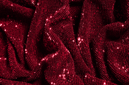 Texture, background, pattern, red fabric with paillettes. Look at these neon red sequins. Round neon pink sparkles glitter overlapping iridescent glitter on a clean purple grid.の写真素材