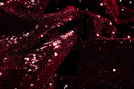 Texture, background, pattern, red fabric with paillettes. Look at these neon red sequins. Round neon pink sparkles glitter overlapping iridescent glitter on a clean purple grid.の写真素材