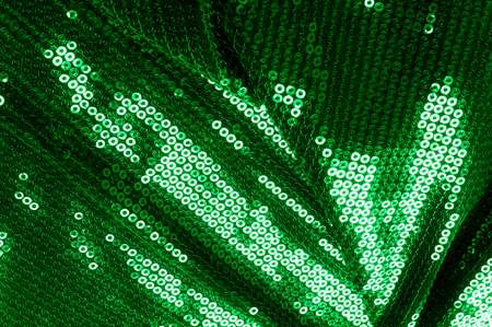 Background texture, pattern. The fabric is dark green with sequins. Make a statement with sequins ! Presenting the stylish Two-toned Paillette Sequins on the nylon spandex stretch backing.の写真素材