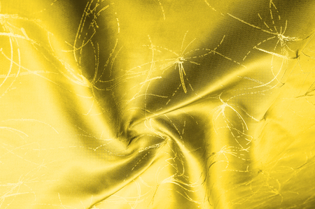 texture Silk fabric Golden yellow with a pattern. Add an unexpected shine of sophistication when introducing this mustard velvet. Soft light velvet depicts a playfully twirled design in decadent gold.の写真素材