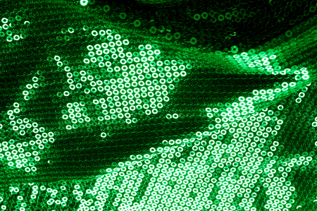 Background texture, pattern. The fabric is dark green with sequins. Make a statement with sequins ! Presenting the stylish Two-toned Paillette Sequins on the nylon spandex stretch backing.の写真素材