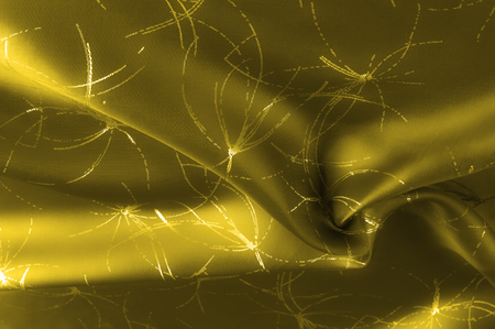 texture Silk fabric Golden yellow with a pattern. Add an unexpected shine of sophistication when introducing this mustard velvet. Soft light velvet depicts a playfully twirled design in decadent gold.の写真素材