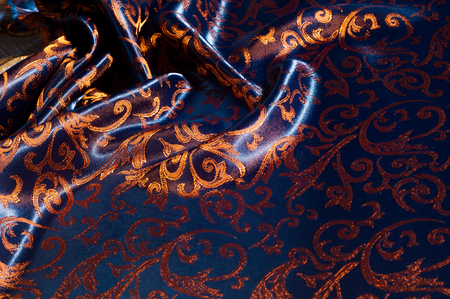 Texture, background, pattern. silk cloth Royal monogram. Moses Velvet with a design of gold foil lilies. Soft, light velvet depicts a playfully twirled design in decadent gold.の写真素材