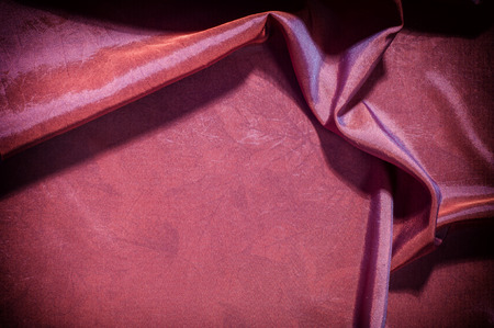 Texture, background, pattern. fabric silk dark maroon. Silk organza mood, but with a beautiful satin face. This fabric has a crunchy drape of organza, but one face is a brilliant satin.の写真素材