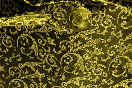 silk cloth Royal monogram. Yellow is dark. This is a black silk velvet with a royal gold seal, creating a negative space patterned picture. Light weight, great for design.の写真素材