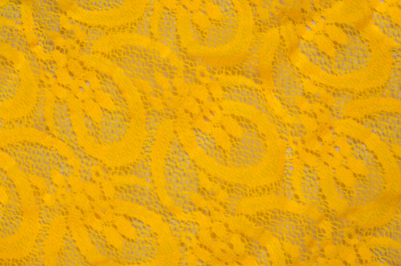 Texture, fabric, background. Lacy Yellow fabric, lace. A thin open fabric, usually cotton or silk, made by a loop, twisting or knitting on patterns and is used specially for trimming clothes.の写真素材