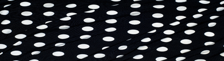 texture of silk fabric. background. white polka dots on a black background. Delicate black and white silky fabric, polka dot background. の写真素材