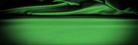 Texture, background, pattern. Fabric silk is dark green. Expressing harmony, global appeal, The combination of green and black, color purple contains passion, strength and energy. Green color,の写真素材