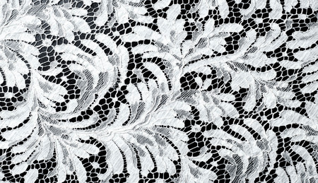Lace fabric texture. lace on black background studio. thin fabric made of yarn or thread. typically one of cotton or silk, made by looping, twisting, or knitting thread in patternsの写真素材