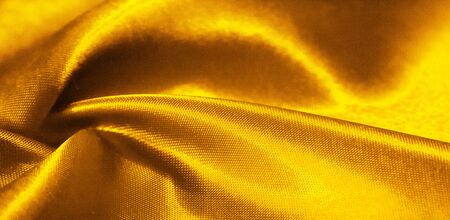Texture, background, pattern, silk fabric in yellow. This adorable, soft and shiny fabric has a smooth mink surface, perfect for creating your projects.の写真素材