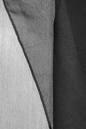 Background texture of silk fabric. This is a natural black scarf, this beautiful nylon satin made of rayon with a transparent hand and a wonderful sheen is perfect for your projects..の写真素材
