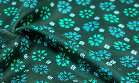 silk fabric of green color with blue and white flowers, dense fabric, bilateral on the basis of...