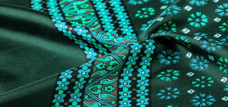 silk fabric of green color with blue and white flowers, dense fabric, bilateral on the basis of triacetate fibers.の写真素材