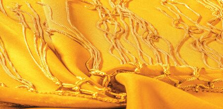 Background texture of silk fabric. This is a natural yellow scarf, this beautiful nylon satin made...