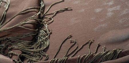 Background texture of silk fabric. This is a natural brown scarf, this beautiful nylon satin made of artificial silk with a clear hand and a wonderful sheen is perfect for your projects.の写真素材