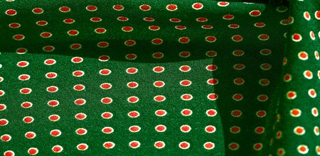 Texture background, pattern,  green silk fabric with red polka dots. Light and silky-soft satin pendant is perfect for your design, online projects. It is also perfect for screensavers and wallpapersの写真素材